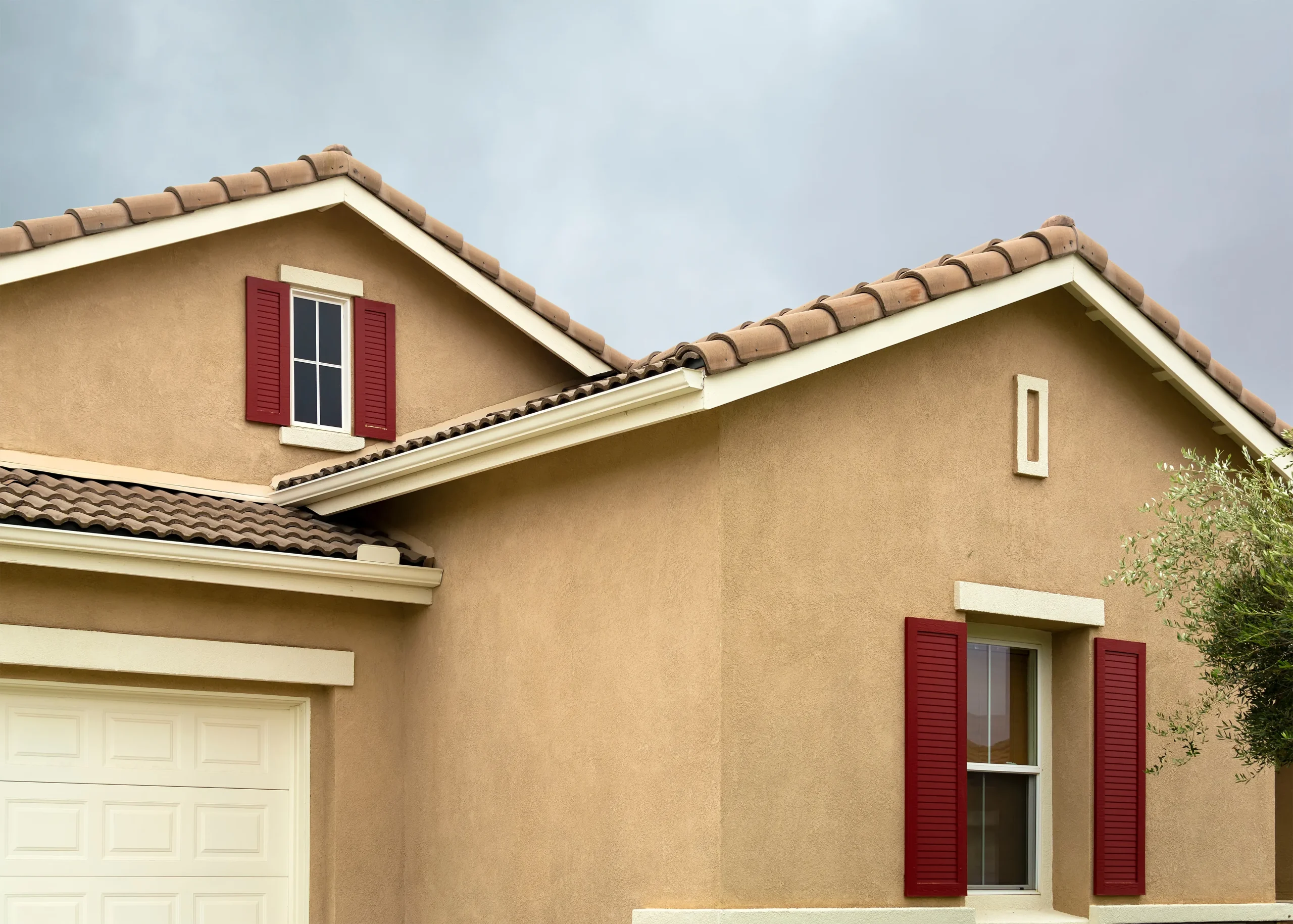 Modern facade blending smooth white stucco with dark grey stone veneer.