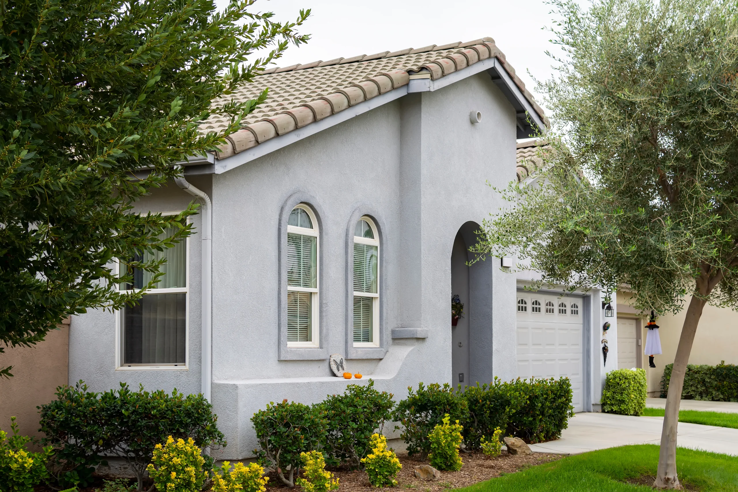 Architectural detail of a smooth, slate-grey stucco wall under bright sunlight.